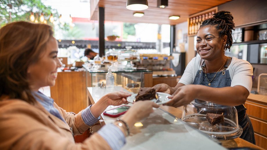 A woman making a payment at a cafe