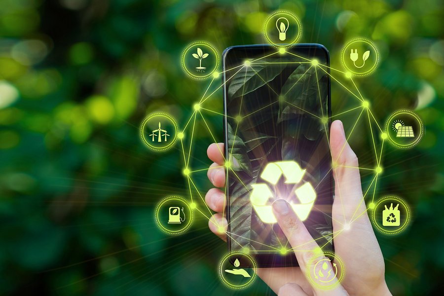 Digital composite image of person using smartphone with green recycling icons